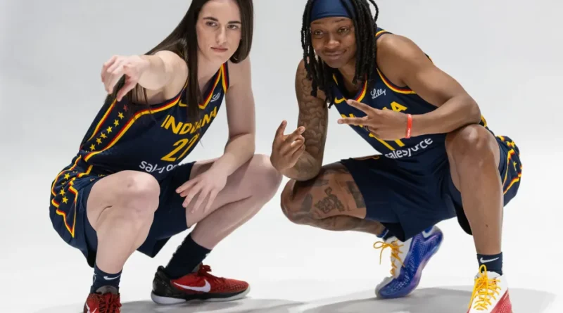 two women in basketball uniforms posing for a picture